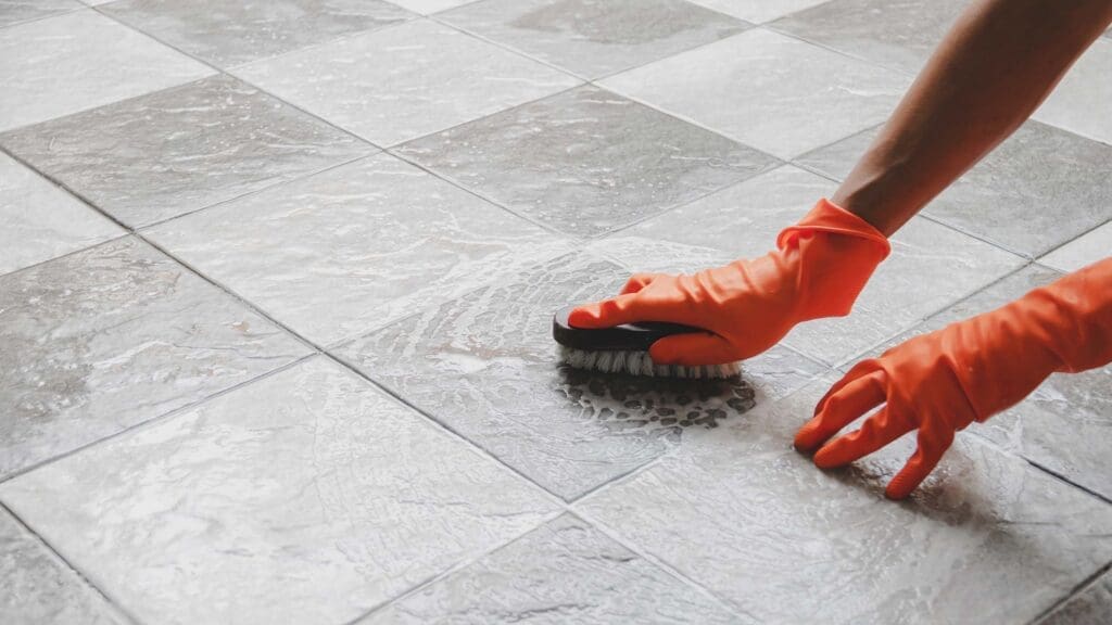 a person is cleaning the floor with brush