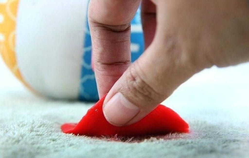 close shot of a hand and slime, removing slime from carpet