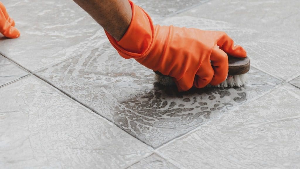 close shot of scrubbing tiles with brush.