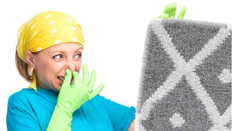 a woman holding a stinky carpet in her hand and second hand on her nose.