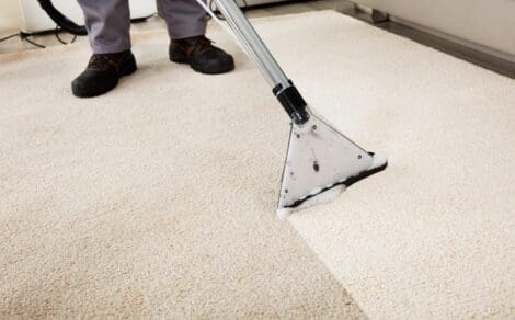 Person Cleaning Carpet With Vacuum Cleaner